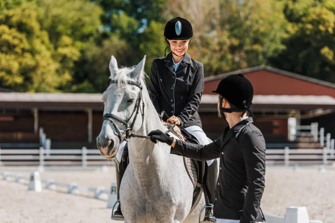 Reiterin auf weißem Pferd beim Training – Sattlerei Preiss Sattelreparatur
